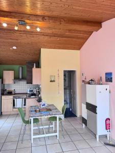 a kitchen with a table and chairs and a refrigerator at La petite Lotie in Saint-Denis-dʼOléron