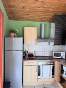 a kitchen with a white refrigerator and wooden cabinets at La petite Lotie in Saint-Denis-dʼOléron +6 photos