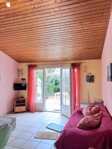 a bedroom with a bed and a wooden ceiling at La petite Lotie in Saint-Denis-dʼOléron
