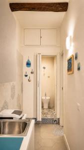 a bathroom with a sink and a toilet at Domus Valeria - Suite Boutique Centro Storico Murales Odissea in Sperlonga +17 photos