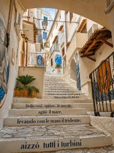 a set of stairs in an alley with a sign on it at Domus Valeria - Suite Boutique Centro Storico Murales Odissea in Sperlonga