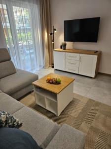 a living room with a tv and a table with fruit on it at Blue Wave Pobierowo in Pobierowo