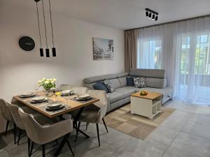 a living room with a table and a couch at Blue Wave Pobierowo in Pobierowo