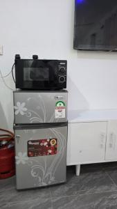 a microwave oven sitting on top of a refrigerator at TINTIN HOMES Mtwapa in Mtwapa