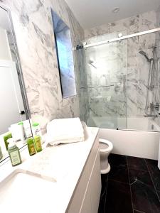 a bathroom with a shower and a toilet and a sink at Luxury EW Bed & Breakfast in Abbotsford +8 photos