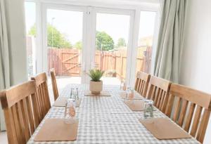 a long table with chairs and a table set for a meal at Willow View Streamside Retreat near Kynren Durham in Newton Aycliffe