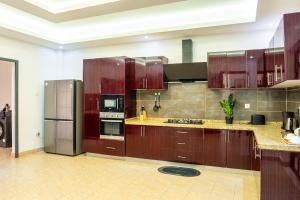 a large kitchen with wooden cabinets and stainless steel appliances at Mandela Suite, Ngor Almadies, Dakar, Senegal Appart 2 chambres, 2 salles de bain in Dakar