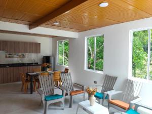a living room with a table and chairs and windows at La Terraza in Villeta