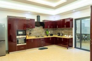 a large kitchen with wooden cabinets and appliances at Mandela Suite, Ngor Almadies, Dakar, Senegal Appart 2 chambres, 2 salles de bain in Dakar +26 photos