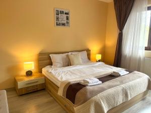 a bedroom with a bed with two towels on it at Chic Peak Apartment - Kalinderu Slope & View in Buşteni