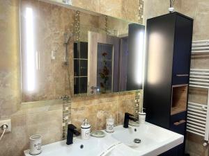 a bathroom with a sink and a mirror at Chic Peak Apartment - Kalinderu Slope & View in Buşteni +20 photos