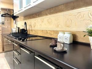 a kitchen with two coffee cups on a counter at Chic Peak Apartment - Kalinderu Slope & View in Buşteni