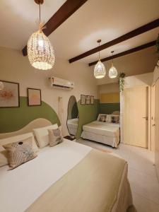 a bedroom with two beds and two pendant lights at Solar Águas Pipa Stays in Pipa +121 photos