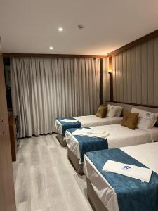 a hotel room with three beds in it at زاده هوتيل - Zade Hotel in Duhok +49 photos