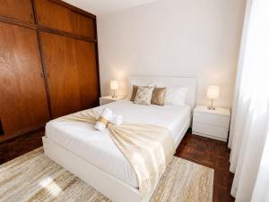 a bedroom with a large white bed with two lamps at Villa Herédia - 5 min form the beach in Ribeira Brava