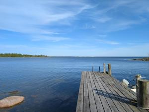a wooden dock on a large body of water at Kuggeboda in Listerby