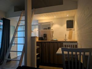 a kitchen with a staircase leading up to a loft at Kuggeboda in Listerby