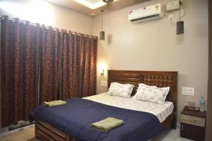 a bedroom with a bed with a blue comforter at JFZ Homestay in Kāsarkod