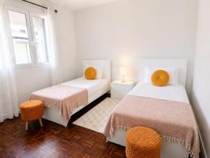 a white room with two beds and a window at Villa Herédia - 5 min form the beach in Ribeira Brava
