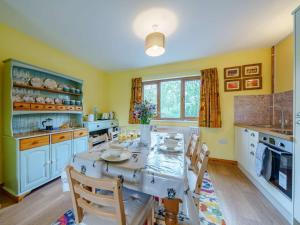 a kitchen with a table and chairs in it at 3 Bed in Brecon oc-83076 in Aber-Brân