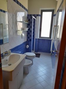a blue and white bathroom with a toilet and a sink at CasaEma in Torre del Lago Puccini