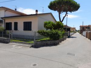 a white house with a fence and a tree at CasaEma in Torre del Lago Puccini