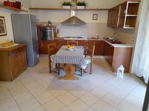 a kitchen with a table with chairs and a refrigerator at CasaEma in Torre del Lago Puccini +11 photos