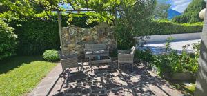 a patio with two chairs and a stone wall at The Hidden Gem, Lago Maggiore in Germignaga +31 photos