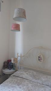 a bedroom with a bed and two lights above it at CasaEma in Torre del Lago Puccini