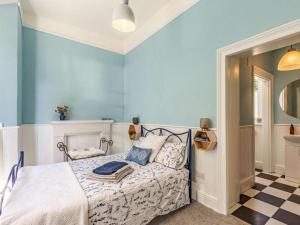 a bedroom with a bed and a blue wall at 1 Bed in Chulmleigh oc-88862 in Chawleigh