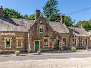 an old brick building with a green door on a street at 1 Bed in Chulmleigh oc-88862 in Chawleigh