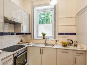 a white kitchen with a sink and a window at 1 Bed in Chulmleigh oc-88862 in Chawleigh +9 photos