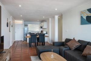 a living room with a couch and a table at Rustic Beachfront Apt! Shared Pool! in Umdloti