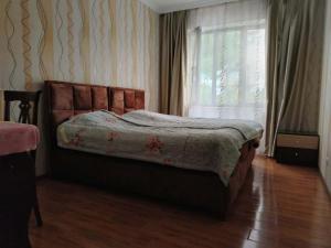a bedroom with a bed and a window and a wooden floor at Apartament 2 in Gonio