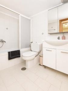a white bathroom with a toilet and a sink at Avra breeze in Kriopigi +23 photos