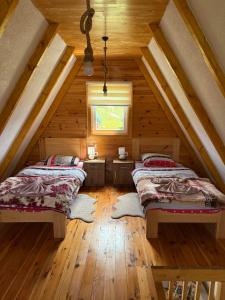 a attic room with two beds and a window at Bungalovi 3AS in Žabljak