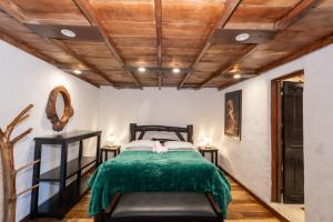 a bedroom with a bed with a green blanket at Finca Campestre La Adelita B&B in Salento +260 photos