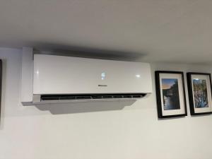 a tv hanging on a wall with three pictures at Sidrós Houses in Vila Nova