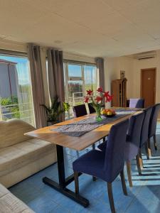 a dining room table with chairs and a couch at Camino apartmani in Dračevo