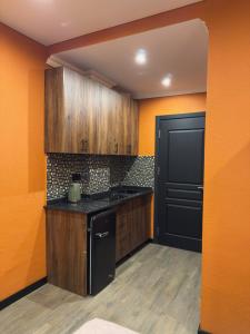 a kitchen with wooden cabinets and a black door at Bellissimo Aparthotel Aqua in Shekhvetili +31 photos