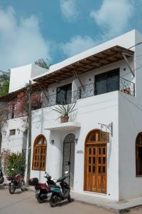 Twee motoren geparkeerd voor een wit gebouw. bij Casa Beu Hotel Boutique in Puerto Escondido