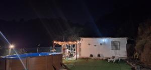 a house with a swimming pool at night at La casa del rio cauche in Almogía