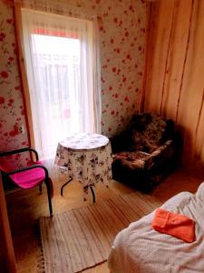 a room with a table and a chair and a window at Imantass in Salacgrīva
