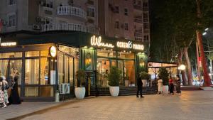 a store on a street with people walking in front of it at Zafran Smart Luxury Suite in Dushanbe