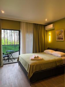 a bedroom with a large bed with towels on it at Bellissimo Aparthotel Aqua in Shekhvetili