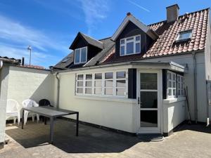 a white house with a picnic table in front of it at Møllevej in Hjørring