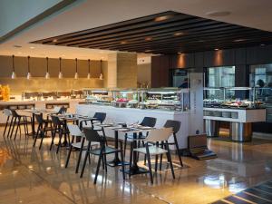 a restaurant with tables and chairs and a counter at Novotel Tunis in Tunis