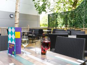 a table with two glasses of wine on top of it at ibis Styles Haydock in Haydock