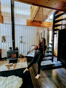a woman sitting on a swing in a room at Maison Conteneur d'Expedition in Amos