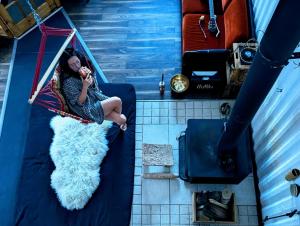 a woman sitting on a bed looking in a mirror at Maison Conteneur d'Expedition in Amos +43 photos